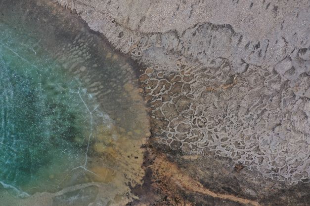 First place: aerial photo of land meeting a shoreline of water and ice